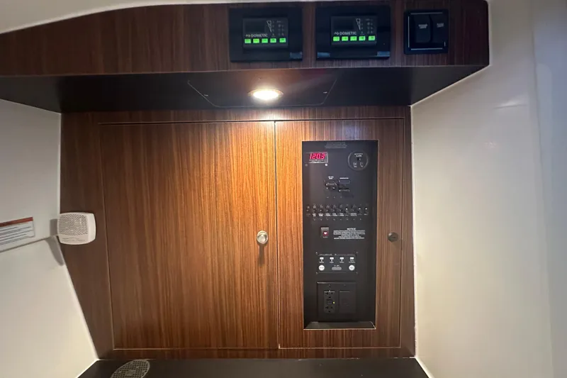 Slide: The Image of Control panel inside 2023 Pursuit DC 326 Dual Console boat, featuring wood finish and digital displays. - 41