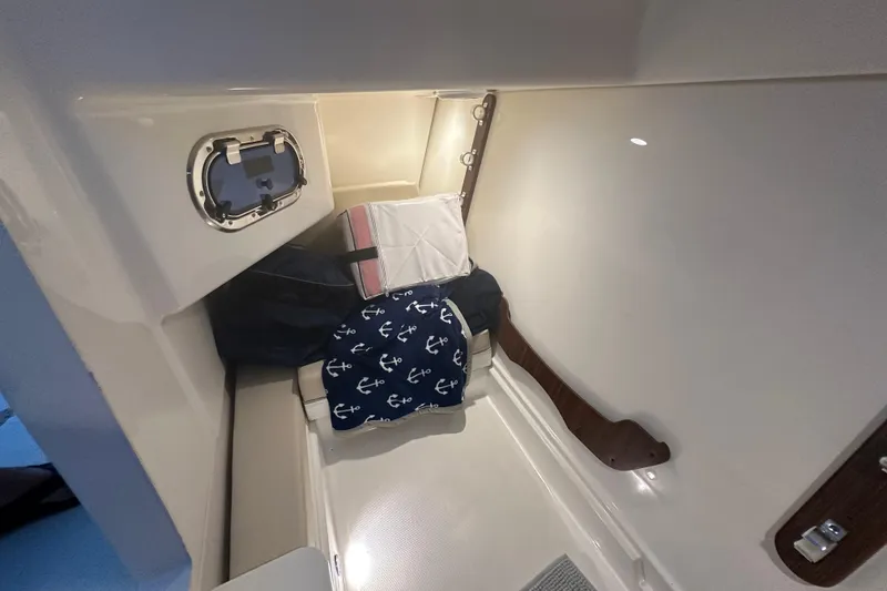 Slide: The Image of 2023 Pursuit DC 326 cabin interior with anchor-themed cushion and porthole. - 42