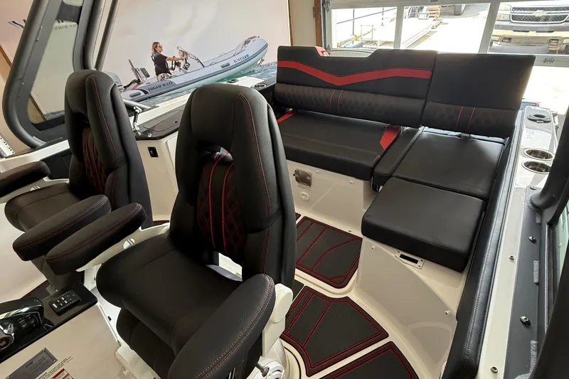 Slide: The Image of Interior of 2026 Monterey Elite 27 SD boat with black and red seating. - 11