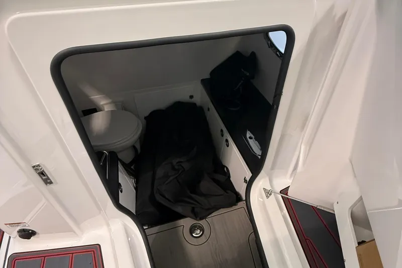 Slide: The Image of Interior cabin of 2026 Monterey Elite 27 SD boat with toilet and storage area. - 14