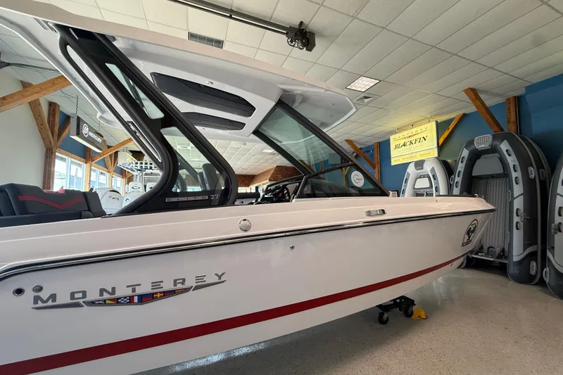 Slide: The Image of 2026 Monterey Elite 27 SD boat displayed indoors with inflatable boats in the background. - 6