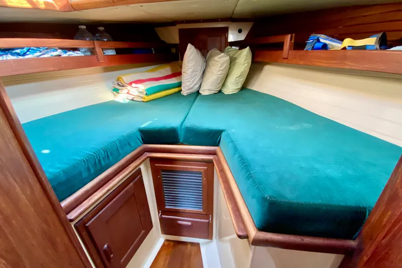 Slide: The Image of Cozy cabin interior of 1993 Pacific Seacraft 34 sailboat with teal cushions and wooden accents. - 17