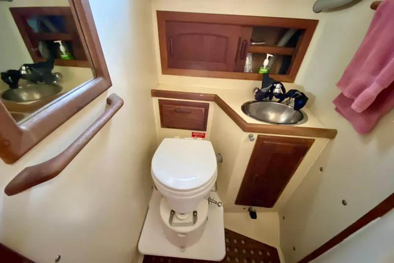 Slide: The Image of Compact bathroom in a 1993 Pacific Seacraft 34 sailboat with sink, toilet, and storage. - 18