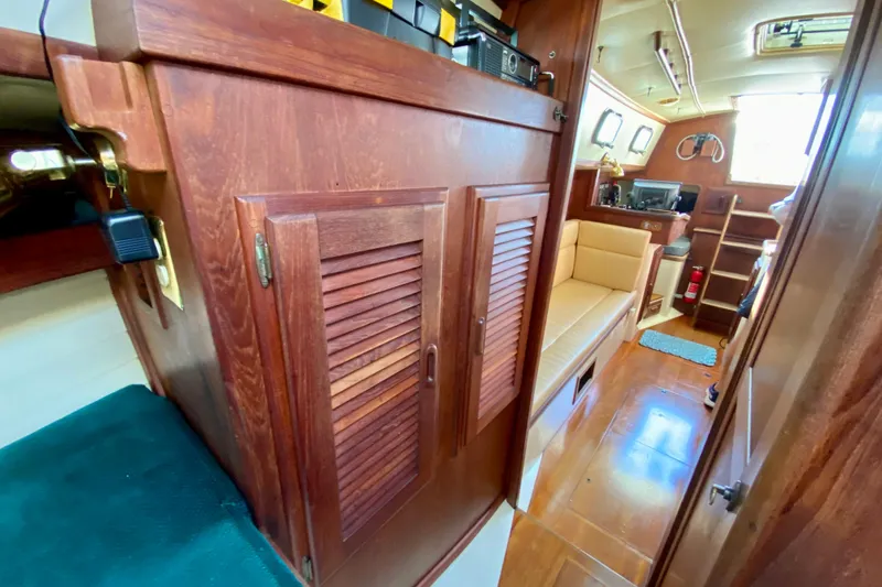 Slide: The Image of Interior of 1993 Pacific Seacraft 34 sailboat with wooden cabinetry and seating area. - 19