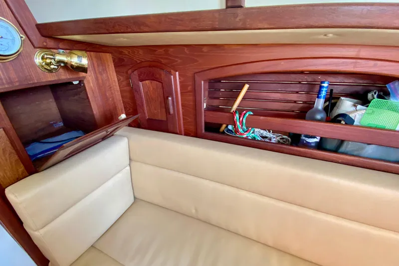 Slide: The Image of Interior of 1993 Pacific Seacraft 34 sailboat with beige seating and wooden storage. - 21
