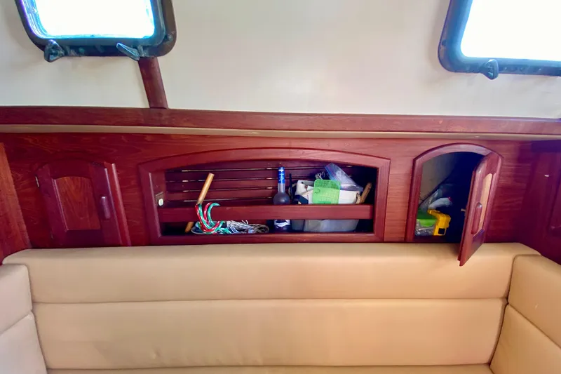 Slide: The Image of Interior of 1993 Pacific Seacraft 34 sailboat with wooden storage compartments and beige seating. - 22