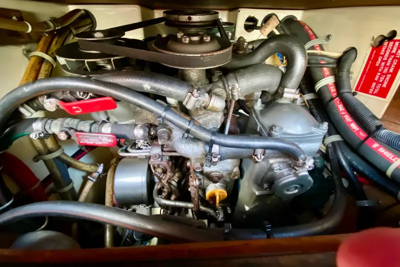 Slide: The Image of Engine compartment of a 1993 Pacific Seacraft 34 sailboat, showcasing hoses and mechanical components. - 24