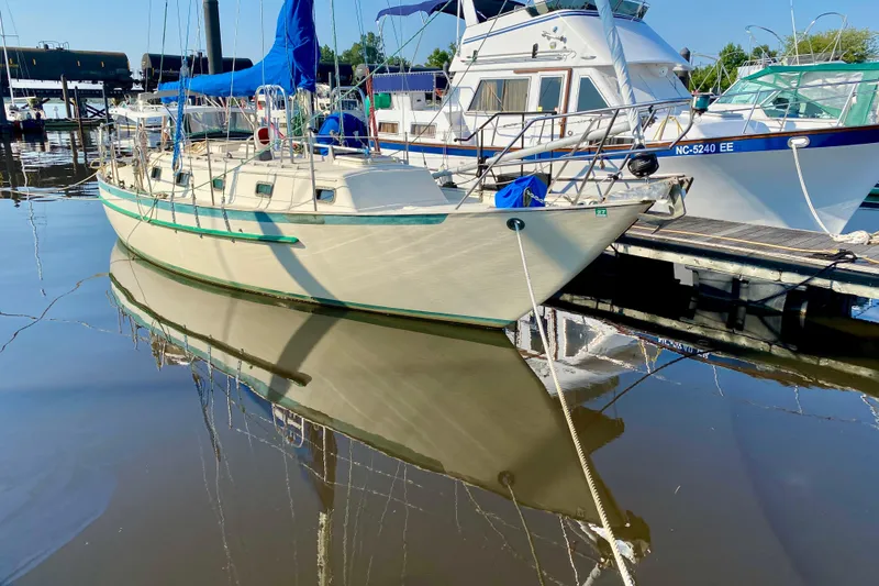 Slide: The Image of Sailboat Pacific Seacraft 34, 1993 model, docked at marina with calm water reflection. - 26