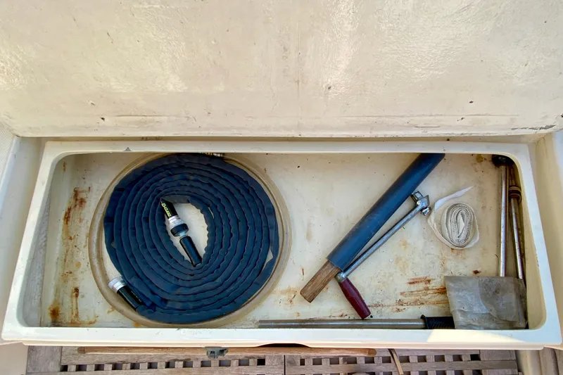 Slide: The Image of Storage compartment on a 1993 Pacific Seacraft 34 with hose and tools. - 8