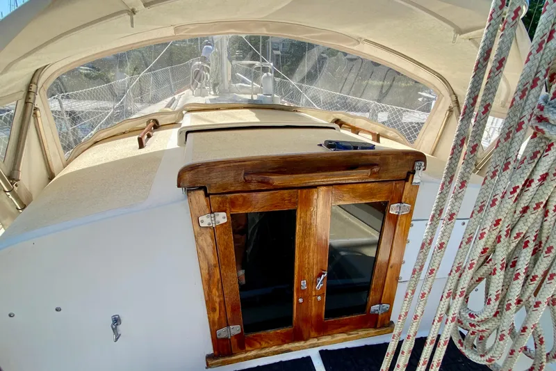 Slide: The Image of 1977 Allied Princess Cutter sailboat cockpit with wooden doors and rigging ropes. - 12