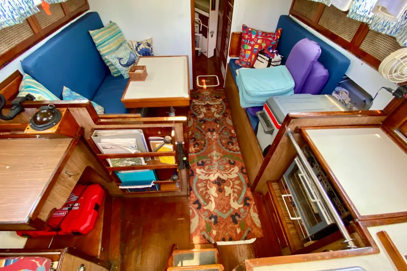 Slide: The Image of Interior of a 1977 Allied Princess Cutter sailboat with cozy seating and nautical decor. - 15
