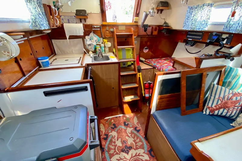 Slide: The Image of Interior of a 1977 Allied Princess Cutter sailboat with cozy seating and nautical decor. - 17