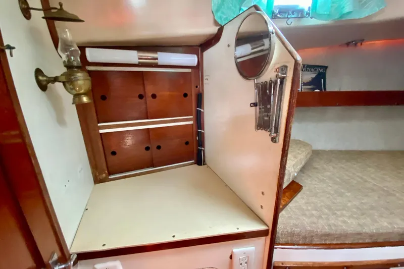 Slide: The Image of Interior of a 1977 Allied Princess Cutter with wooden cabinetry and a cozy sleeping area. - 21