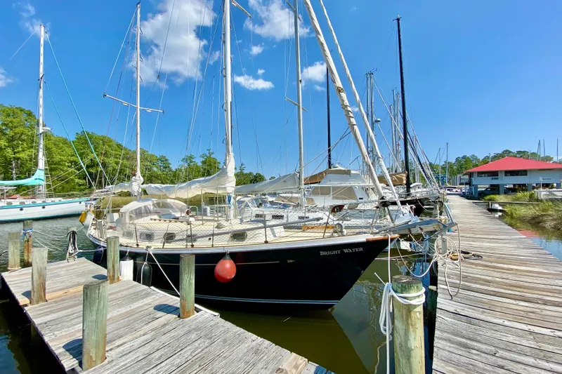 Slide: The Image of 1977 Allied Princess Cutter sailboat docked at a marina under a clear blue sky. - 4