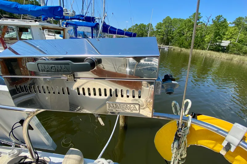 Slide: The Image of Outdoor grill on a 1977 Allied Princess Cutter sailboat, docked by a serene lake. - 9