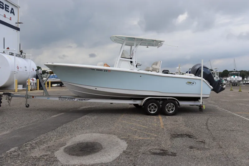 Slide: The Image of 2023 Sea Hunt Ultra 234 boat on trailer in a marina parking lot. - 18