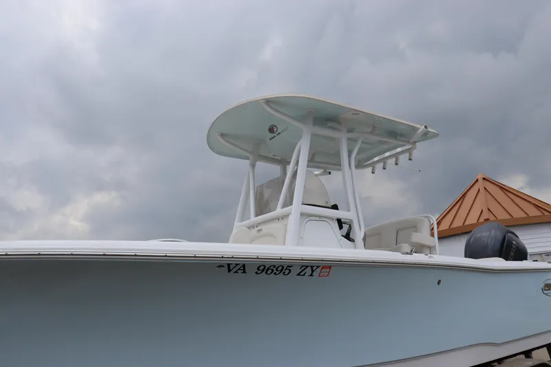 Slide: The Image of 2023 Sea Hunt Ultra 234 boat with T-top against cloudy sky. - 2