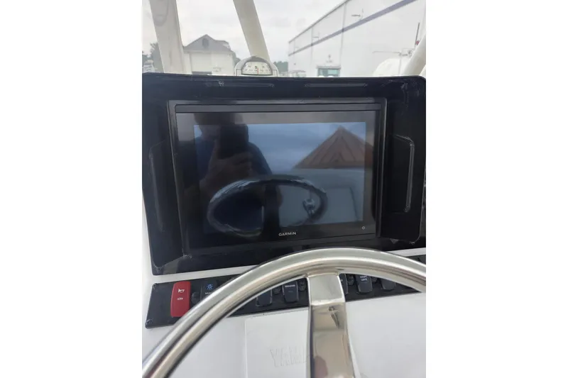 Slide: The Image of 2023 Sea Hunt Ultra 234 boat dashboard with Garmin display and steering wheel. - 25