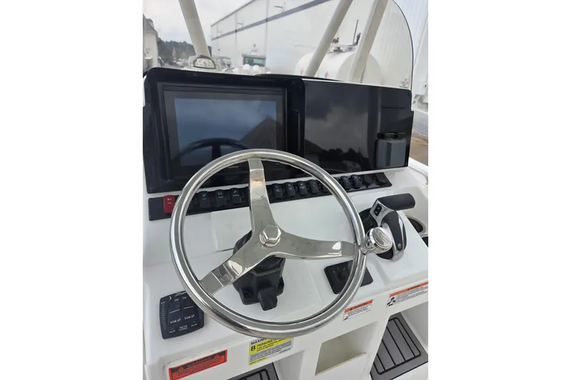 Slide: The Image of 2023 Sea Hunt Ultra 234 boat dashboard with steering wheel and control panel. - 26