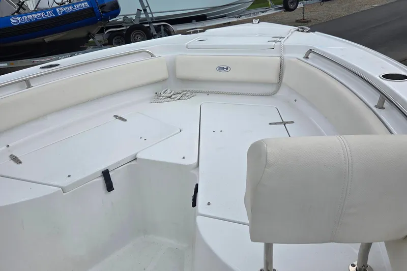 Slide: The Image of 2023 Sea Hunt Ultra 234 boat interior with white seating and storage compartments. - 30