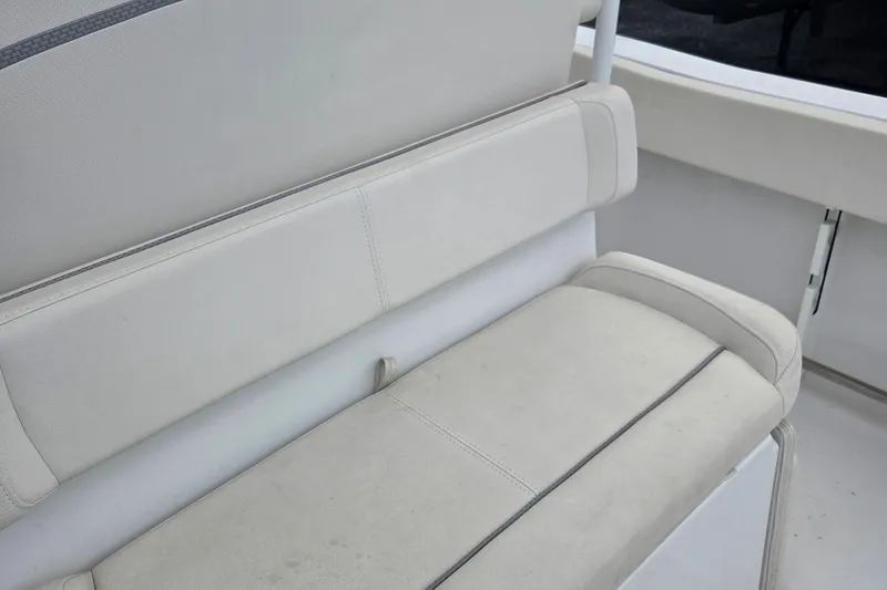 Slide: The Image of 2023 Sea Hunt Ultra 234 boat interior seating, featuring white cushioned bench. - 31