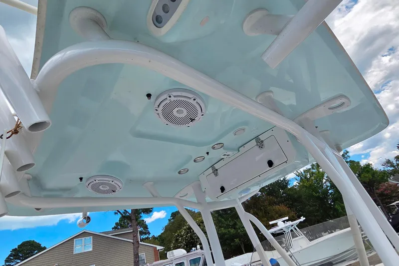 Slide: The Image of 2023 Sea Hunt Ultra 234 boat canopy with speakers and rod holders, under a blue sky. - 33