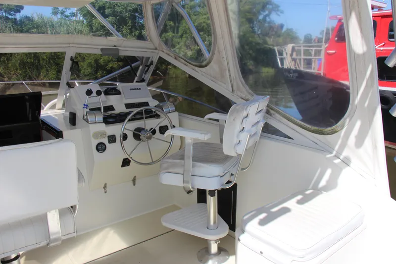 Slide: The Image of 2004 Carolina Classic 28 boat cockpit with steering wheel and control panel. - 11