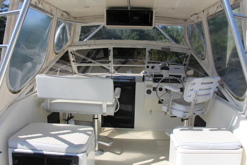 Slide: The Image of 2004 Carolina Classic 28 boat cockpit with steering wheel and seating. - 14