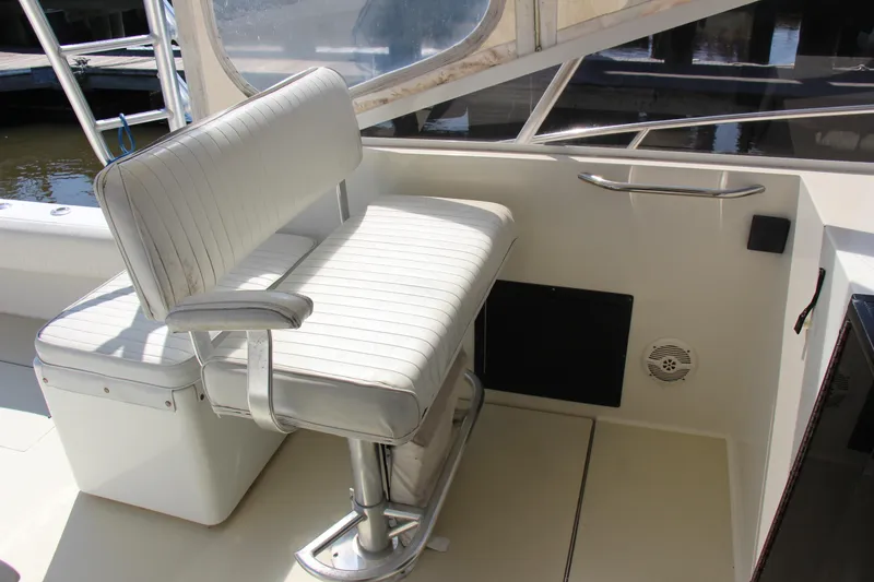 Slide: The Image of 2004 Carolina Classic 28 boat interior with white cushioned seating and metal railing. - 18