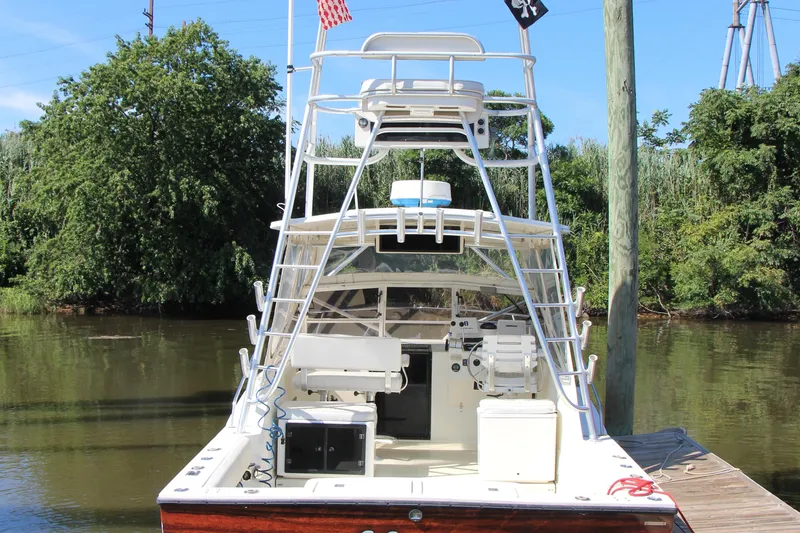 Slide: The Image of 2004 Carolina Classic 28 boat docked by a river, featuring a tower and fishing equipment. - 22