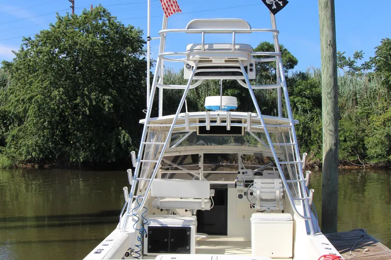 Slide: The Image of 2004 Carolina Classic 28 boat docked by lush greenery and calm water. - 23
