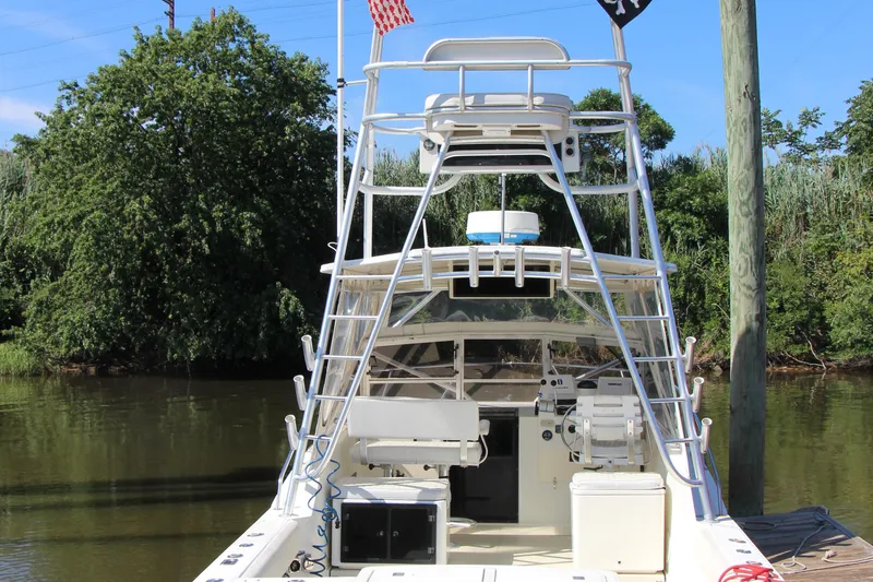 Slide: The Image of 2004 Carolina Classic 28 boat docked by lush greenery and calm water. - 24