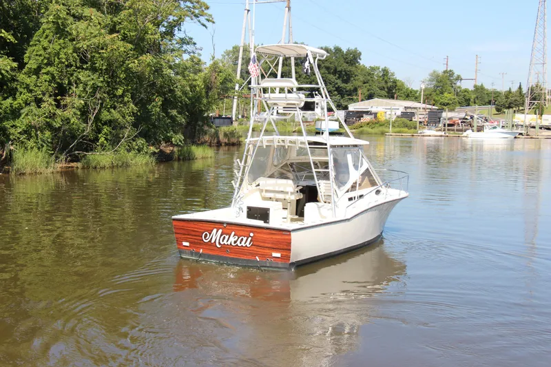 Slide: The Image of 2004 Carolina Classic 28 boat named "Makai" on a calm river. - 26