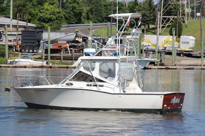Slide: The Image of 2004 Carolina Classic 28 boat docked in a marina, surrounded by industrial background. - 29