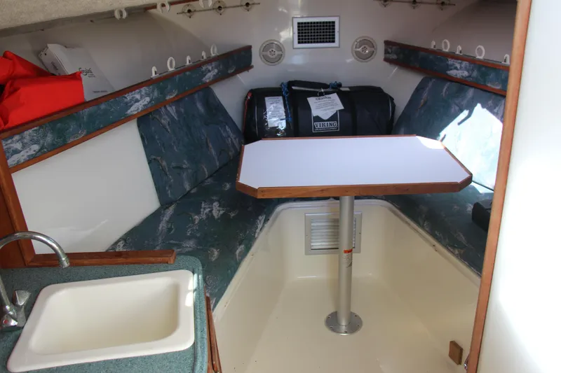 Slide: The Image of 2004 Carolina Classic 28 cabin interior with table, seating, and sink. - 3