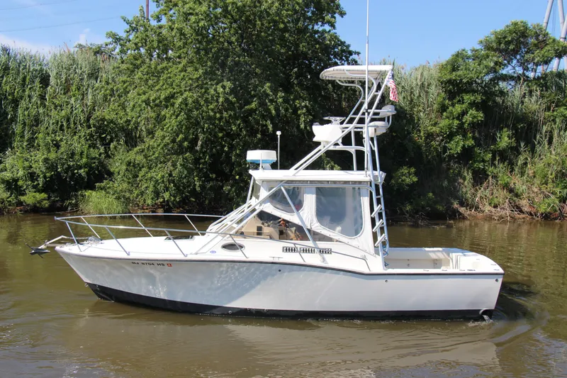 Slide: The Image of 2004 Carolina Classic 28 boat on a calm river with lush greenery. - 39