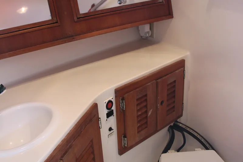 Slide: The Image of 2004 Carolina Classic 28 boat interior with wooden cabinets and sink area. - 6