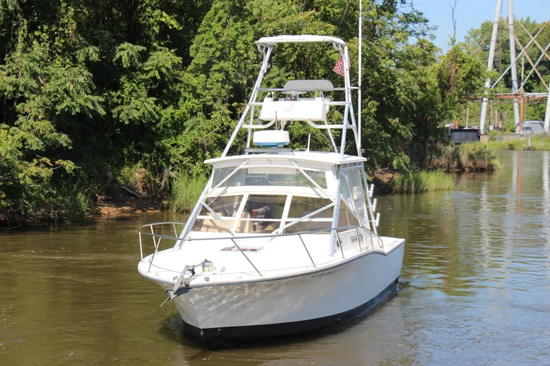 Slide: The Image of 2004 Carolina Classic 28 boat navigating a narrow waterway surrounded by lush greenery. - 68