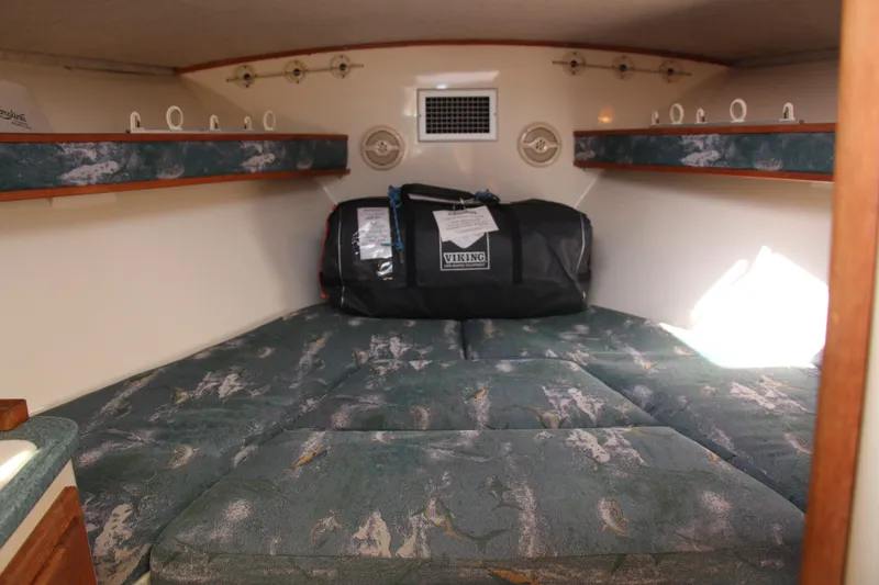 Slide: The Image of Interior cabin of 2004 Carolina Classic 28 boat with cushioned seating and storage. - 7