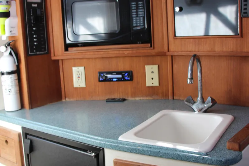 Slide: The Image of 2004 Carolina Classic 28 boat interior with sink, microwave, and fire extinguisher. - 9
