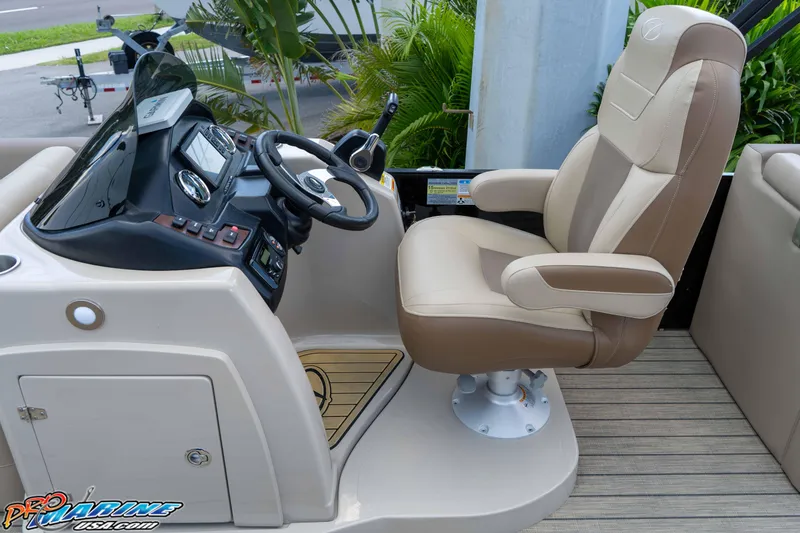 Slide: The Image of Captain's chair and helm of 2022 Veranda Relax VR25RC boat, featuring modern controls and dashboard. - 25
