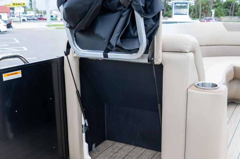 Slide: The Image of 2022 Veranda Relax VR25RC boat interior storage compartment with beige seating and cup holder. - 29