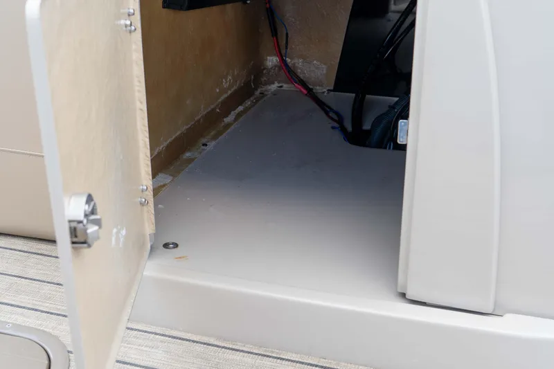 Slide: The Image of Open storage compartment in 2022 Veranda Relax VR25RC boat, showing interior wiring. - 30