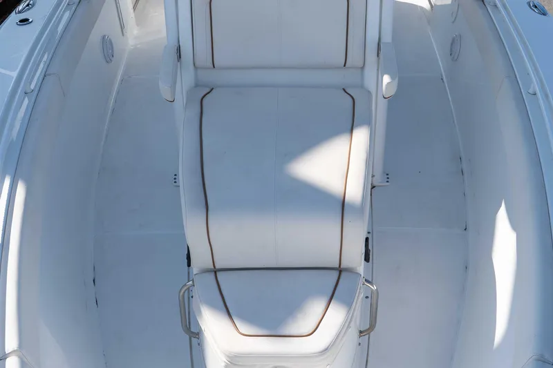 Slide: The Image of 2022 Sea Hunt Gamefish 27 Coffin Box boat interior with white cushioned seating. - 10