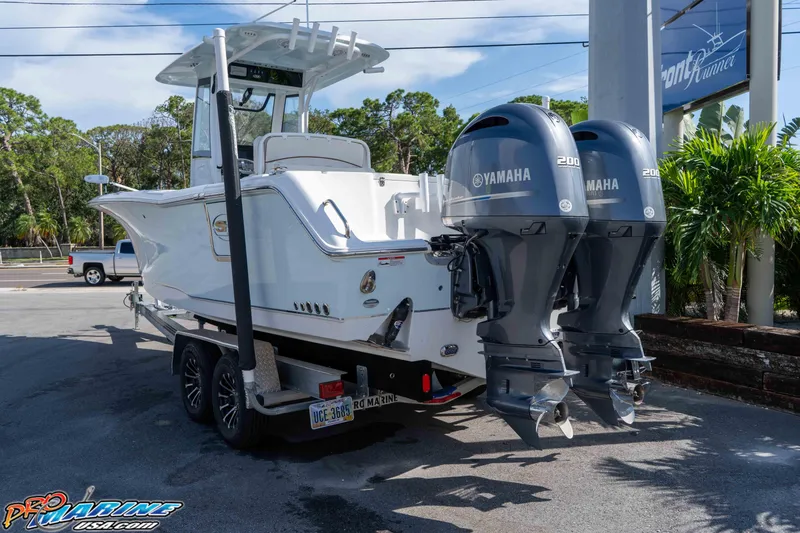 Slide: The Image of 2022 Sea Hunt Gamefish 27 Coffin Box boat with dual Yamaha engines on a trailer. - 5