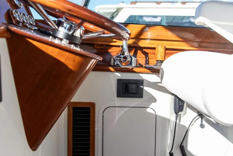 Slide: The Image of Interior of 2023 Hinckley Picnic Boat 34 S, featuring polished wood and modern controls. - 15