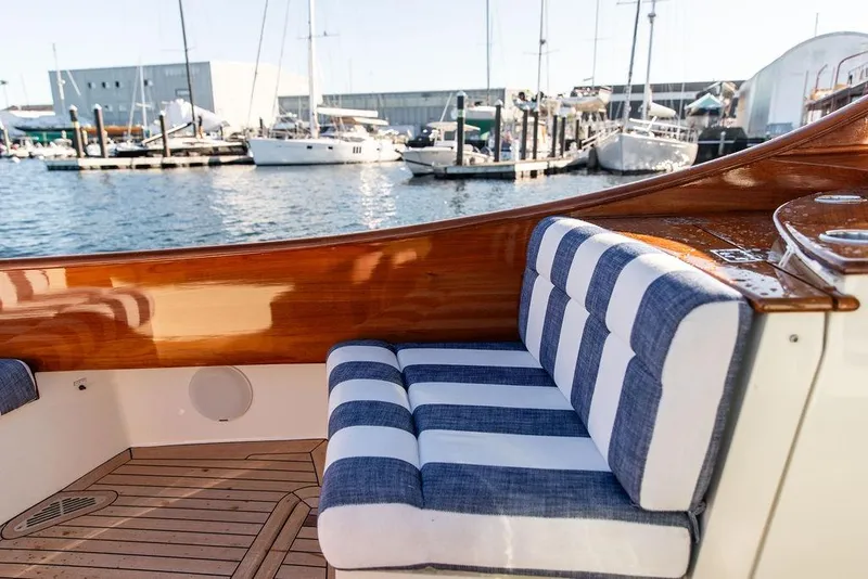 Slide: The Image of 2023 Hinckley Picnic Boat 34 S with striped seating, docked at marina. - 11