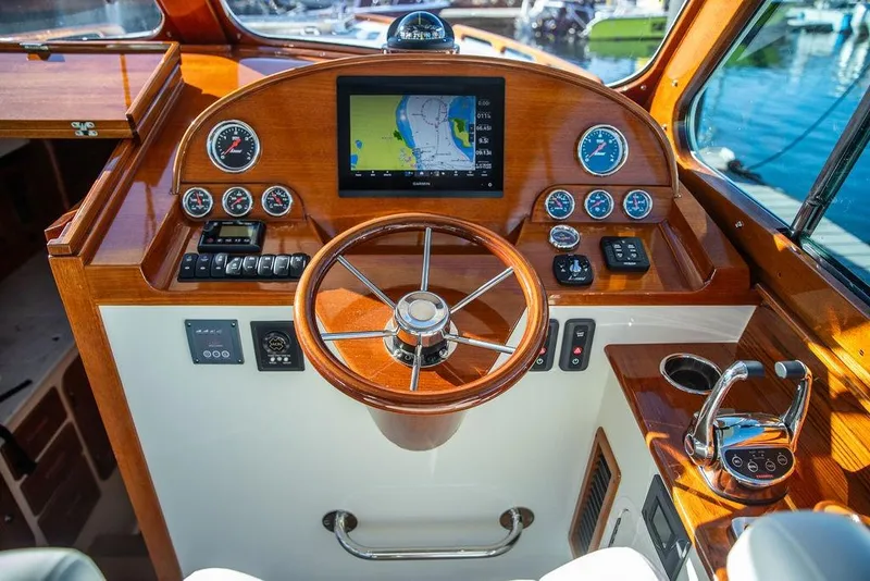Slide: The Image of 2023 Hinckley Picnic Boat 34 S helm with wooden steering wheel and navigation display. - 13