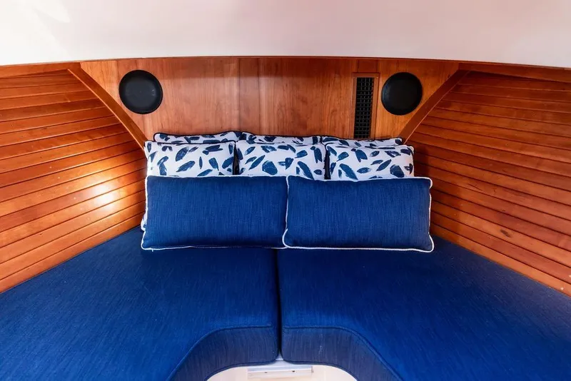 Slide: The Image of Interior of 2023 Hinckley Picnic Boat 34 S with blue cushions and wooden paneling. - 22