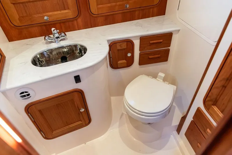 Slide: The Image of 2023 Hinckley Picnic Boat 34 S bathroom with wooden cabinetry and modern fixtures. - 23